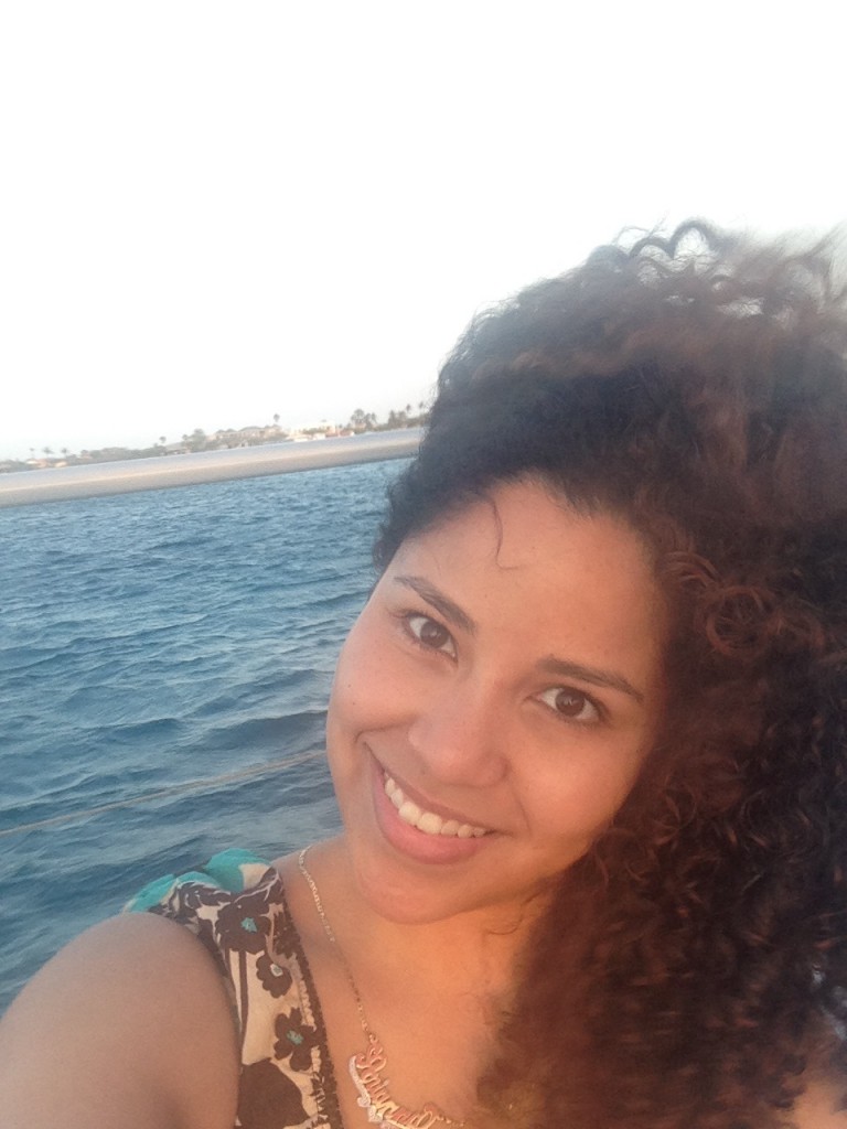 Me, embracing my wild summer curls on a windy boat road in Aruba.